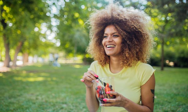 photo of woman eating berries
