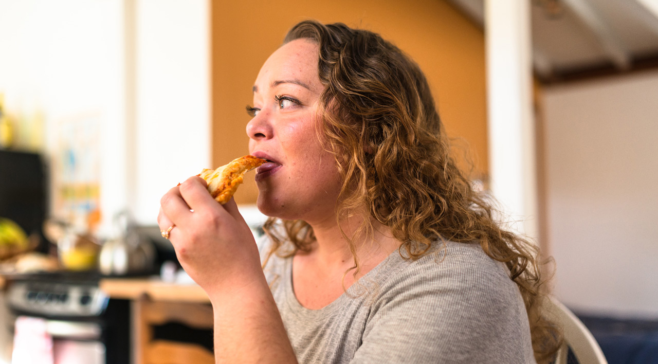 girl eating slice of pizza
