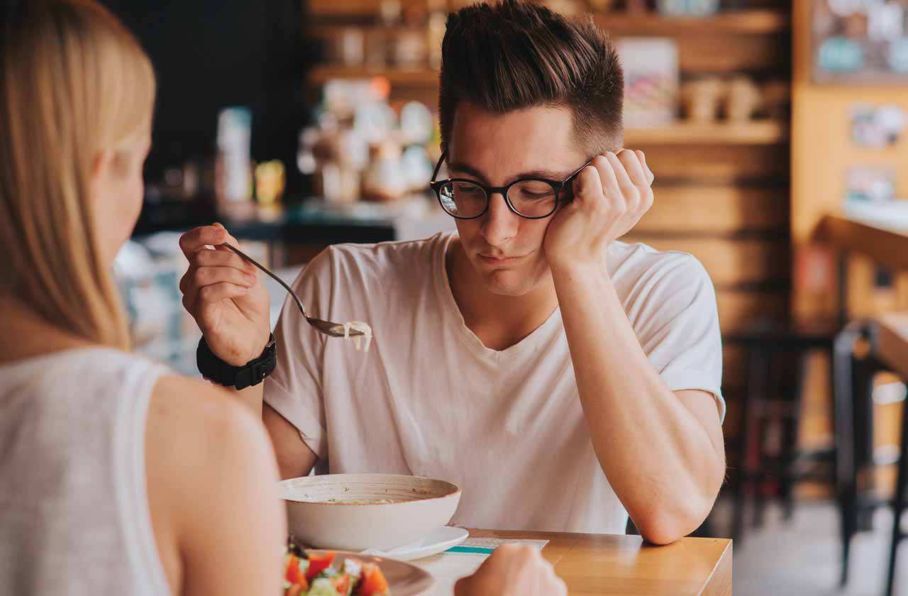 Photo of a couple in a restaurant, with the man not happy with his food