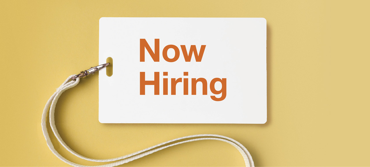 photo of name badge with the words Now Hiring