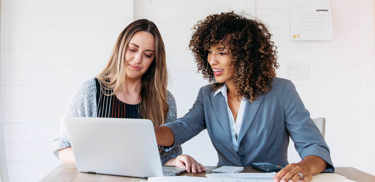 Photo of two women looking at computer