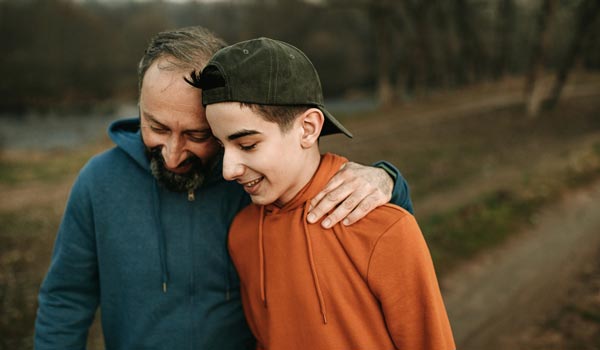 photo of father hugging teen child