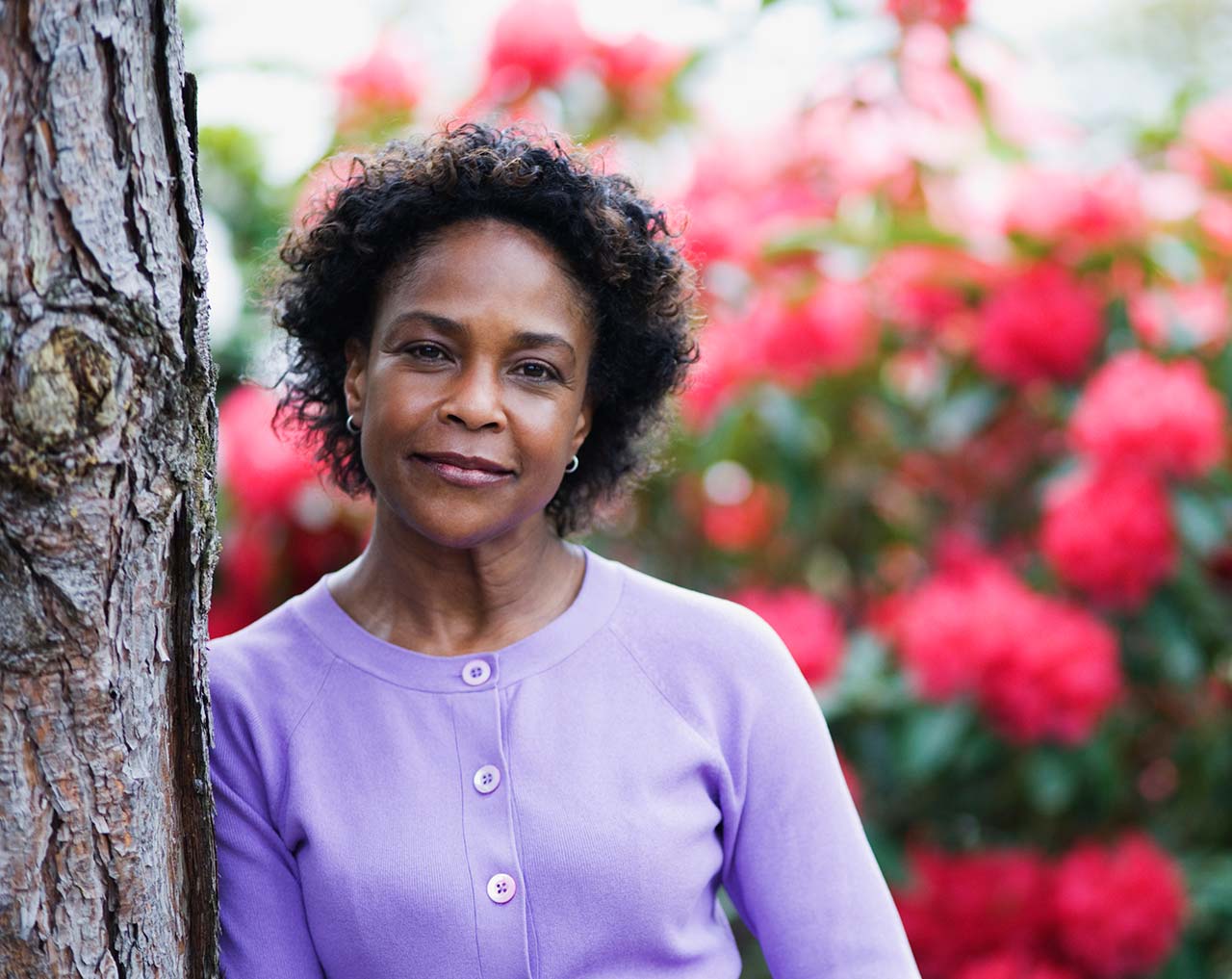 hopeful woman leaning on a tree