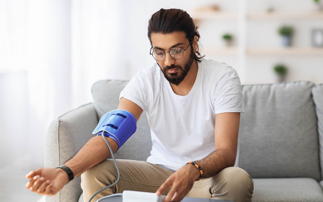 Image of young man measuring blood pressure