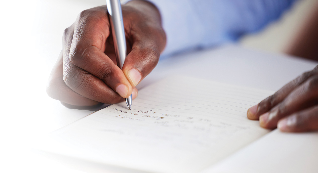 Photo close up of hand writing down notes