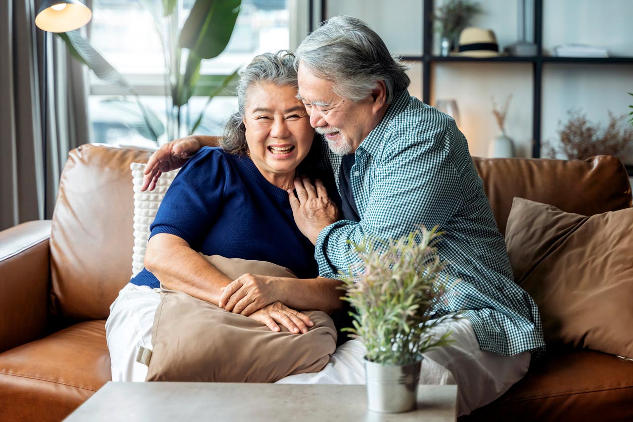 Senior couple together sitting on sofa