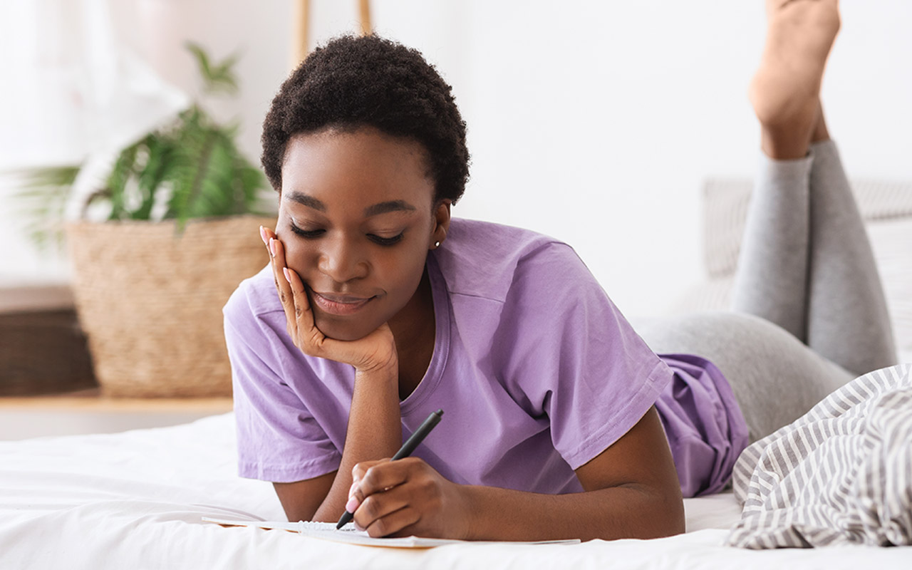 Image of woman writing on a diary