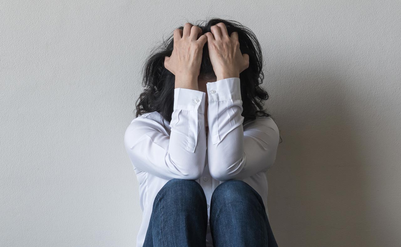 photo of woman holding her head in panic