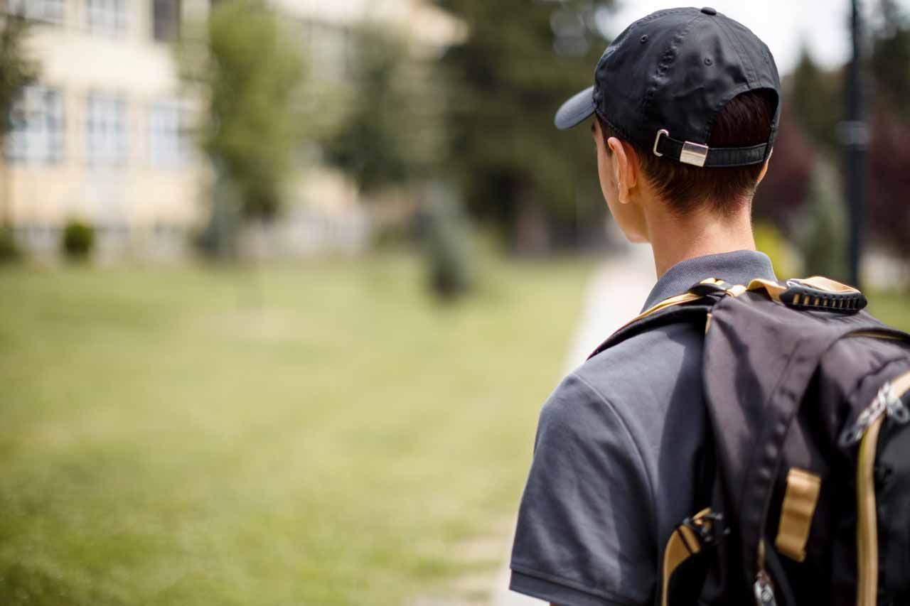 back of teenager looking at school