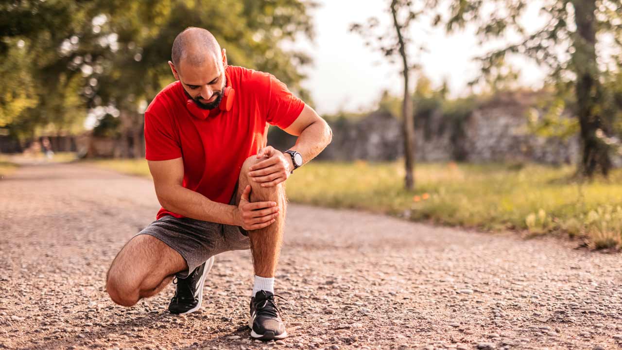 Photo of man holding on to his knee
