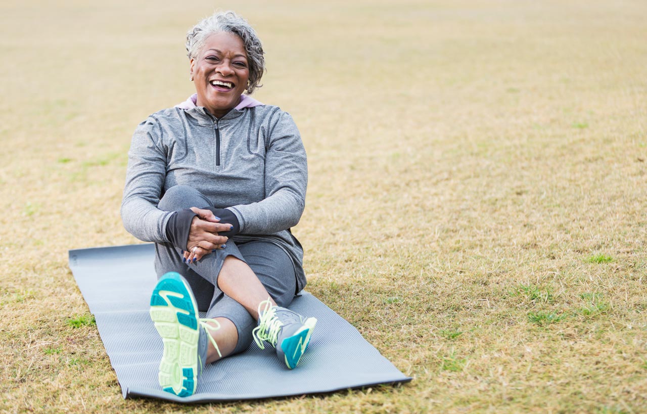 Photo of woman sitting on the grass with her legs crossed in front of her